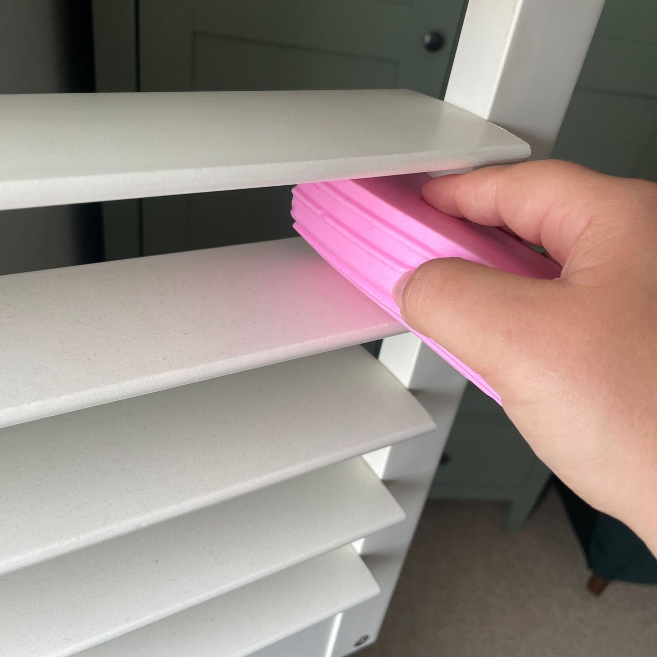 Using a pink Damp Duster to clean the slat of plantation shutters