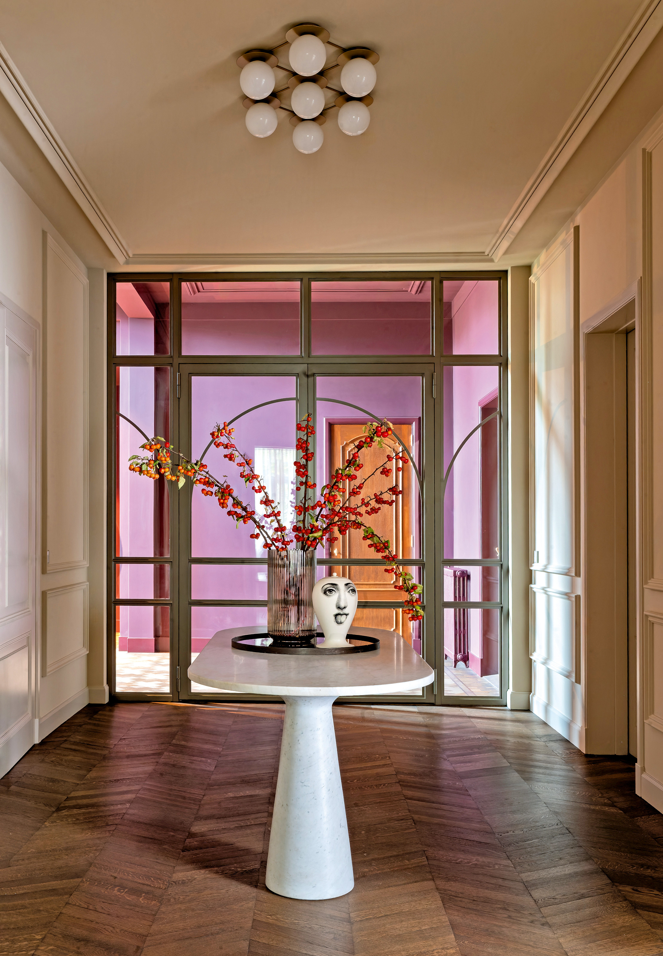 Hallway with parquet floor, butter yellow walls and white table