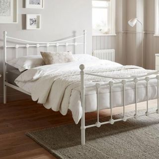 Metal bed frame with white bedding on top