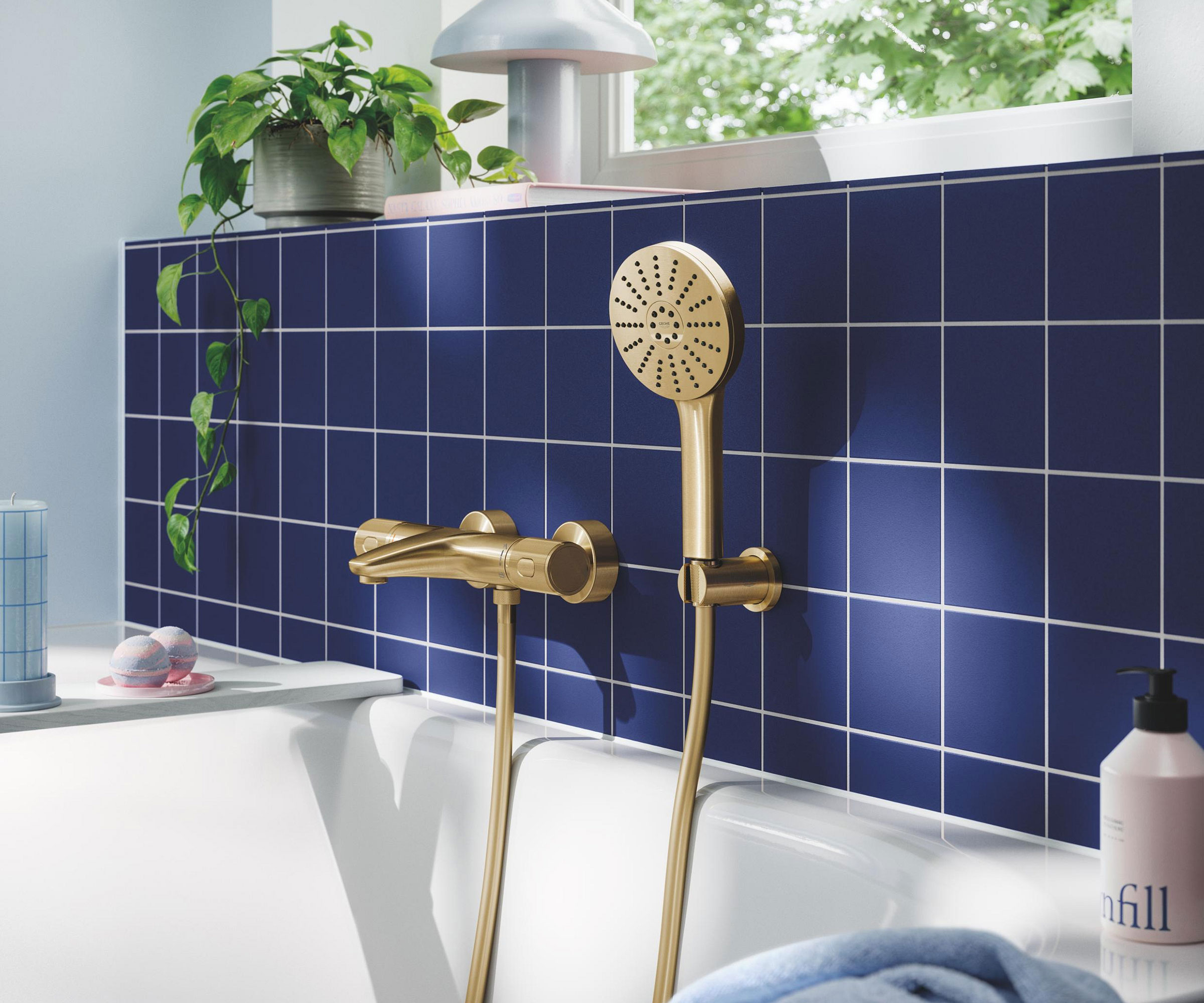 brass mixer shower and bath tap in bathroom with blue wall tiles