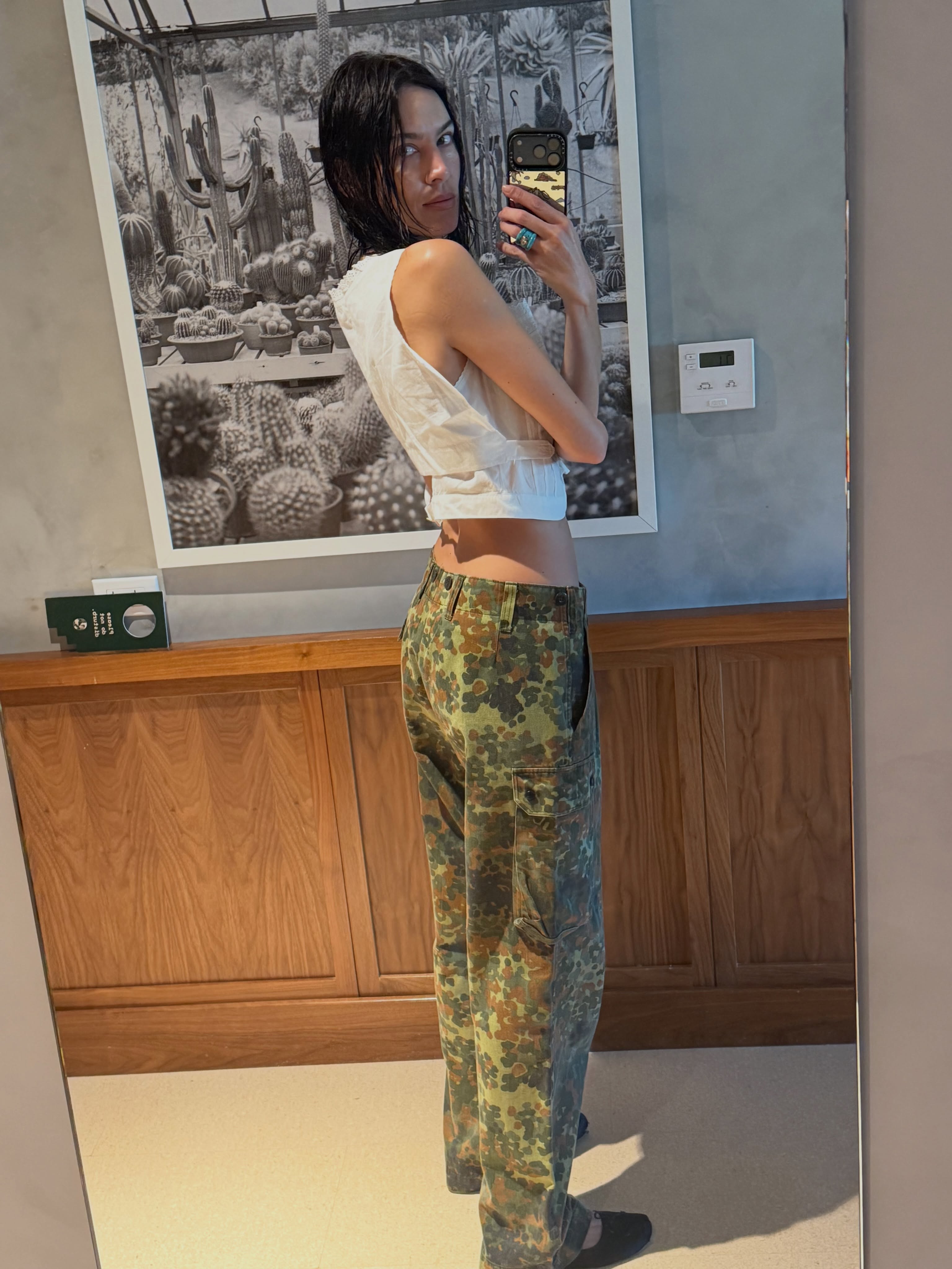 An image of @alexachung wearing camo trousers with ballet flats and a white top.