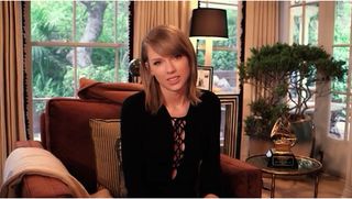 taylor swift in living room sitting on armchair
