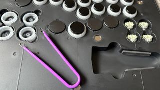 A top-down image of the Victrix Pro KO leverless fight stick's buttons being taken apart