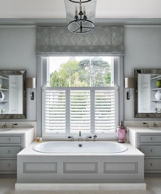 Luxury bathroom with lighting, grey walls and mirrors