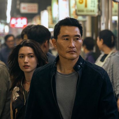 Two people (Reina Hardesty and Daniel Dae Kim, center) walk through a crowded Korean night market, in 'Butterfly.'
