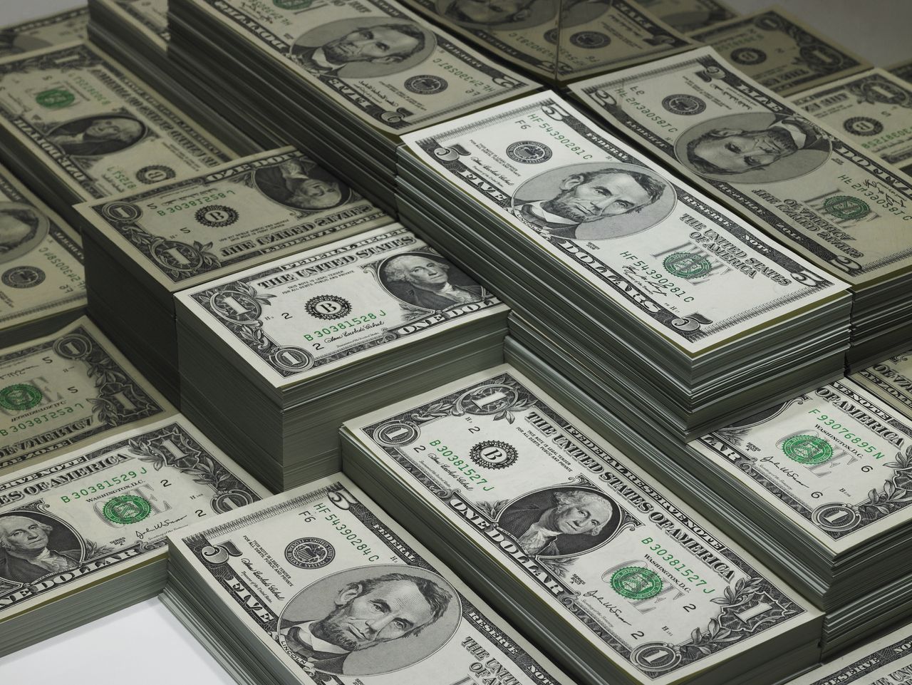 Piles of dollar bills reflected in glass