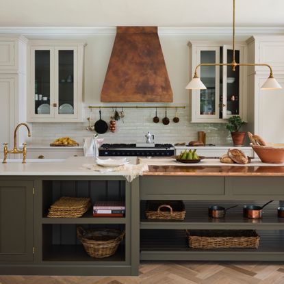 sage green and white kitchen, wooden floor, copper cooker hood, white work tops, kitchen storage 