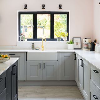 grey corner kitchen with white worktops and sink