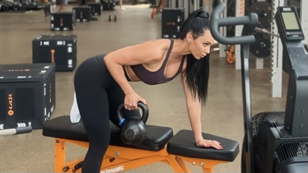 Woman exercising with kettlebells in gym