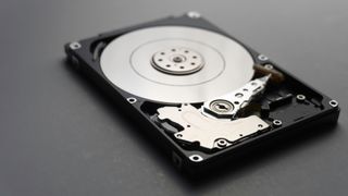 An open hard disk drive with internal disk showing, representing an article on how to clone a hard drive on Windows 
