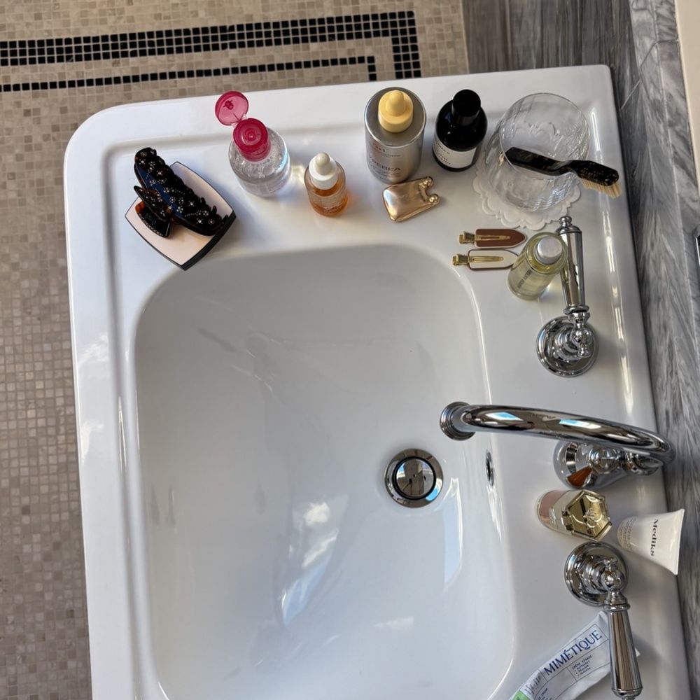 A chic bathroom sink filled with a range of beauty product
