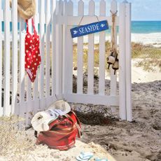 children's canvas bag with activity items on beach