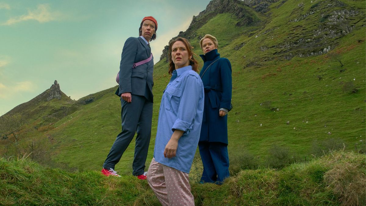 Saoirse, Dara and Robyn stand on a grassy hillside