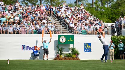  Scottie Scheffler plays his shot from the first hole tee as fans watch from the grandstand during the first round of the RBC Heritage at Harbour Town Golf Links 