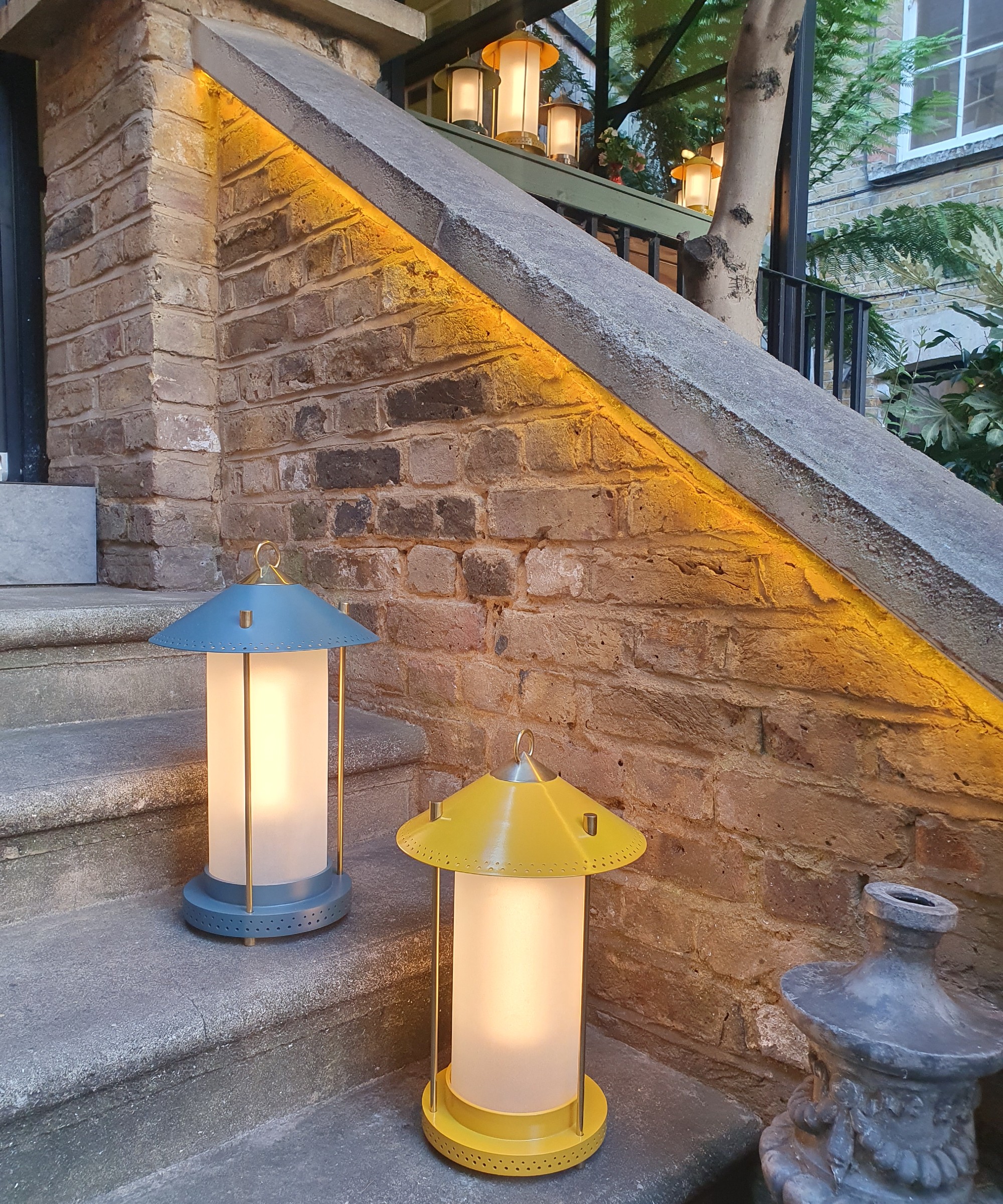The Pooky medium Stefan lanterns by The Novogratz in denim and sand lining outdoor stairs