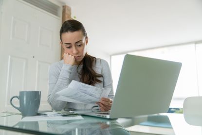 Woman paying her utility bills online and looking worried