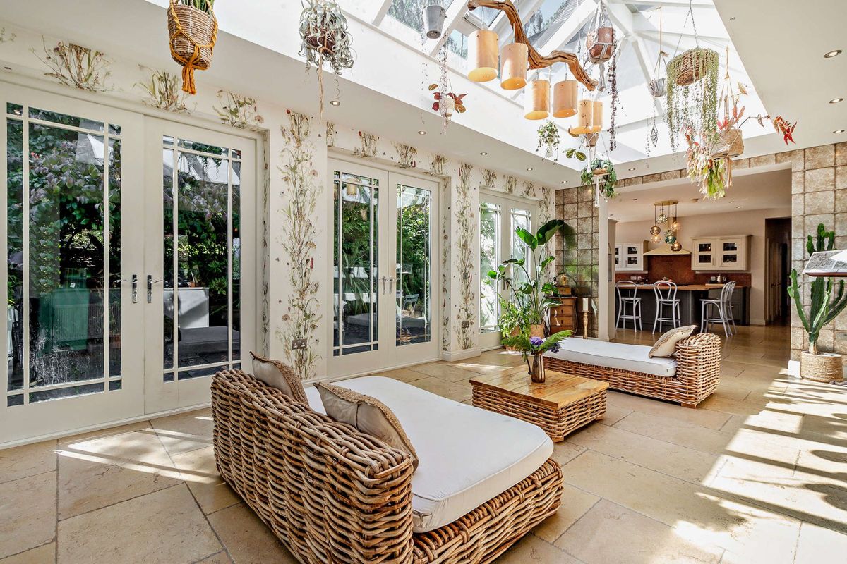The garden room is connected to a dining room and lead to the garden through bifold doors