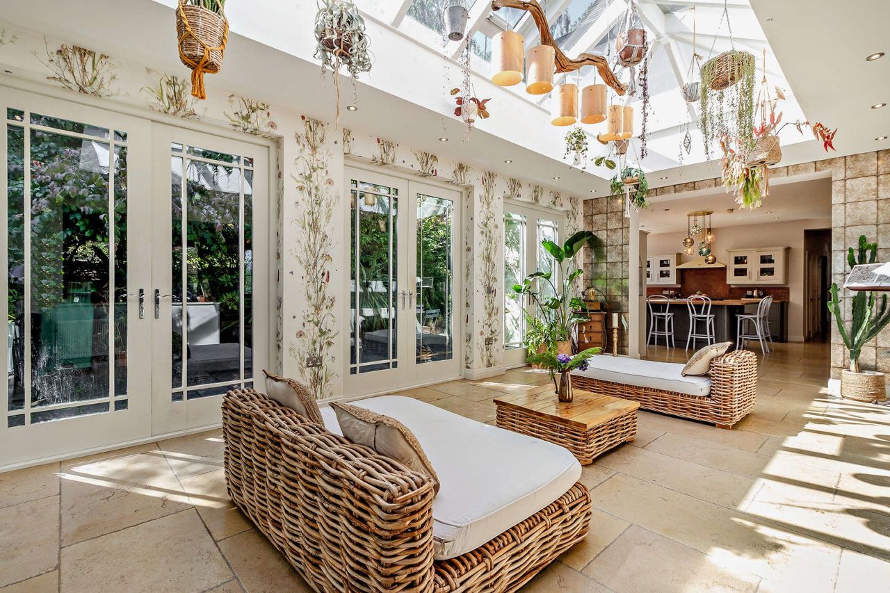 The garden room is connected to a dining room and lead to the garden through bifold doors