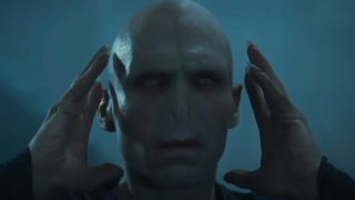 Ralph Fiennes holds his hands to the side of his head in Harry Potter and the Goblet of Fire.