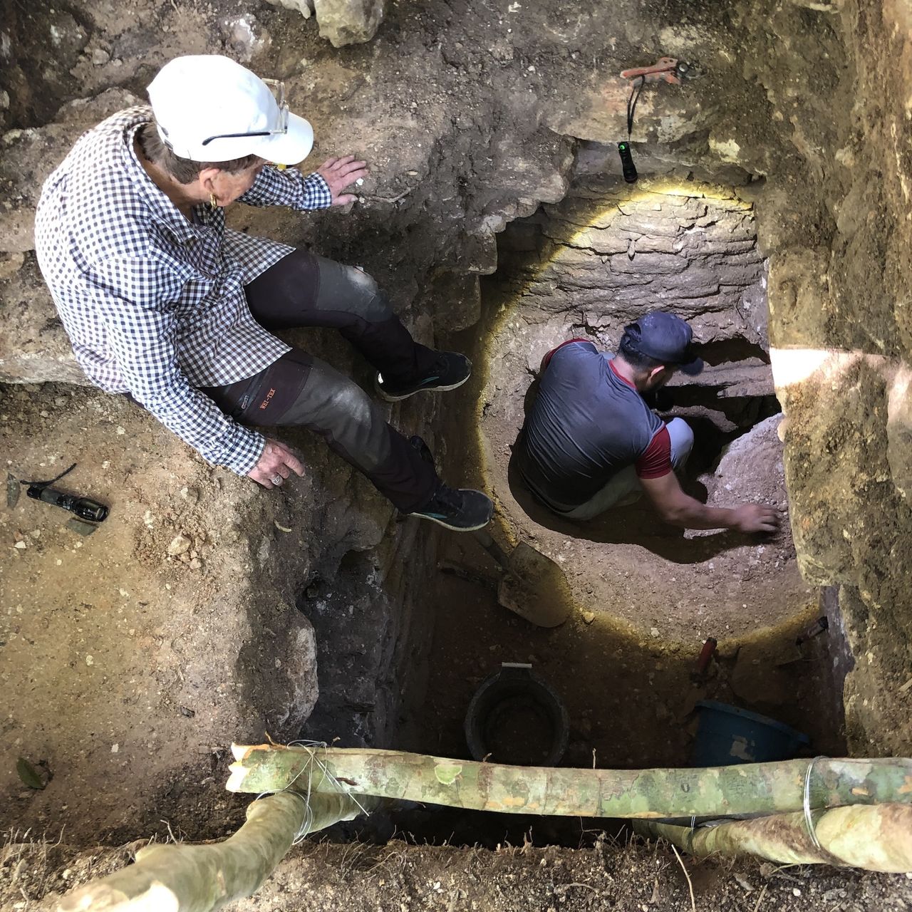 two archaeologists climb into a tomb
