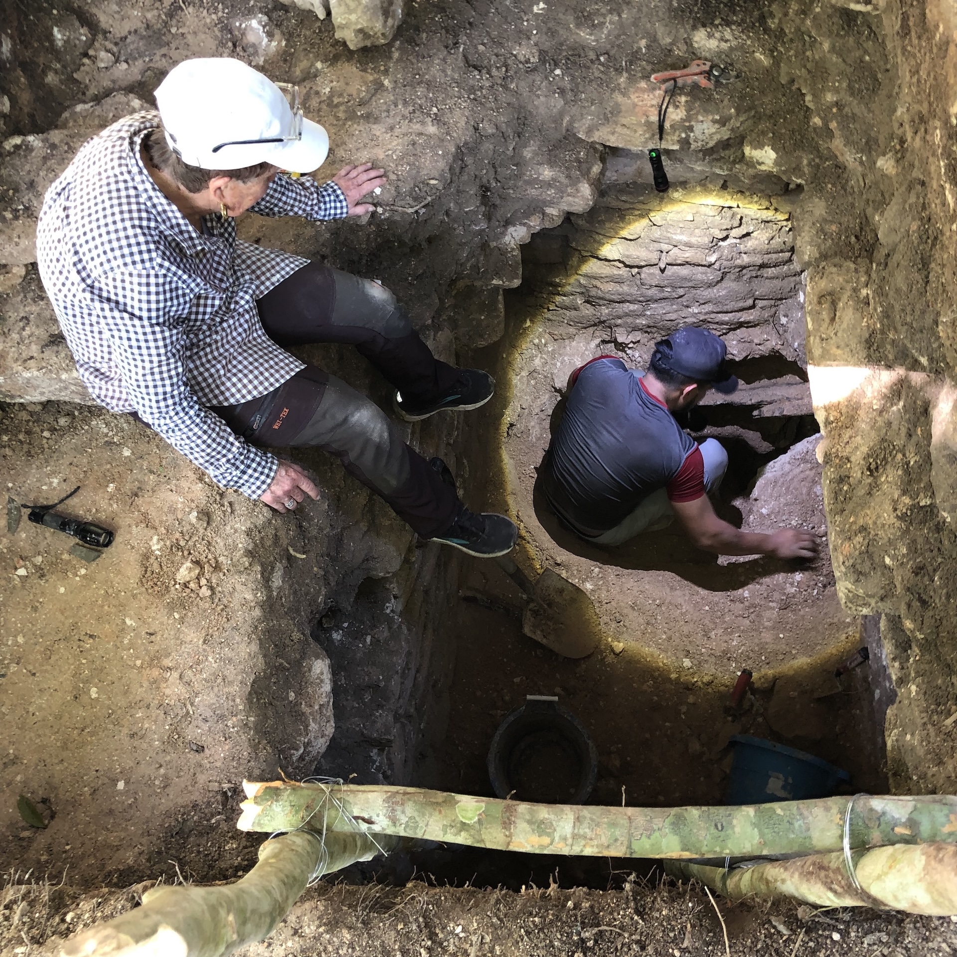 two archaeologists climb into a tomb