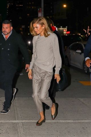 Zendaya wearing gray trousers and Loro Piana Rebecca flats.