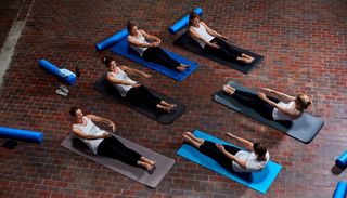 Women performing Pilates roll-up