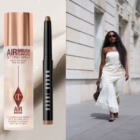 A woman in a white top and pants with long wavy hair. She is next to a bottle of setting spray and an eyeshadow stick.