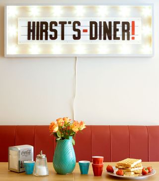 A retro diner light-up sign in a dining room