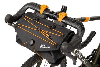 The Jack Wolfskin bikepacking front bar bag is shown mounted on the front of a bike