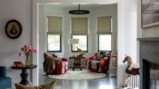 Living room with bay window and colorful patchwork chairs beneath