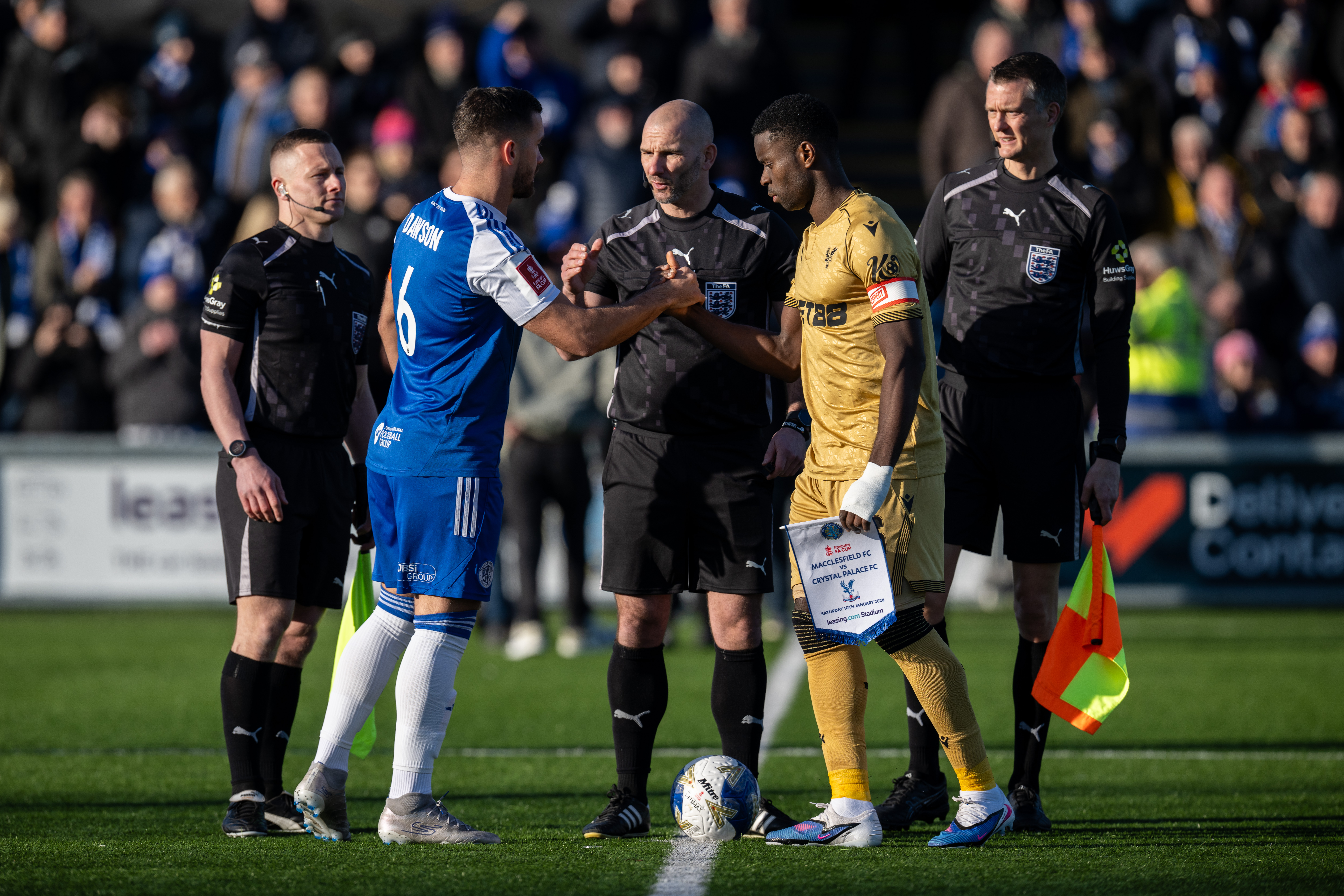 MACCLESFIELD, ENGLAND - JANUARY 10: Referee, Tim Robinson, Assistant Referee Timothy Wood and Wade Smith, Paul Dawson of Macclesfield and Marc Guehi of Crystal Palace during the Emirates FA Cup Third Round match between Macclesfield and Crystal Palace on January 10, 2026 in Macclesfield, England. (Photo by Sebastian Frej/Getty Images)