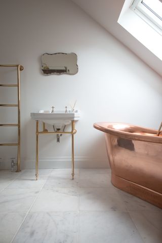 white bathroom with copper bath, marble flooring, loft setting