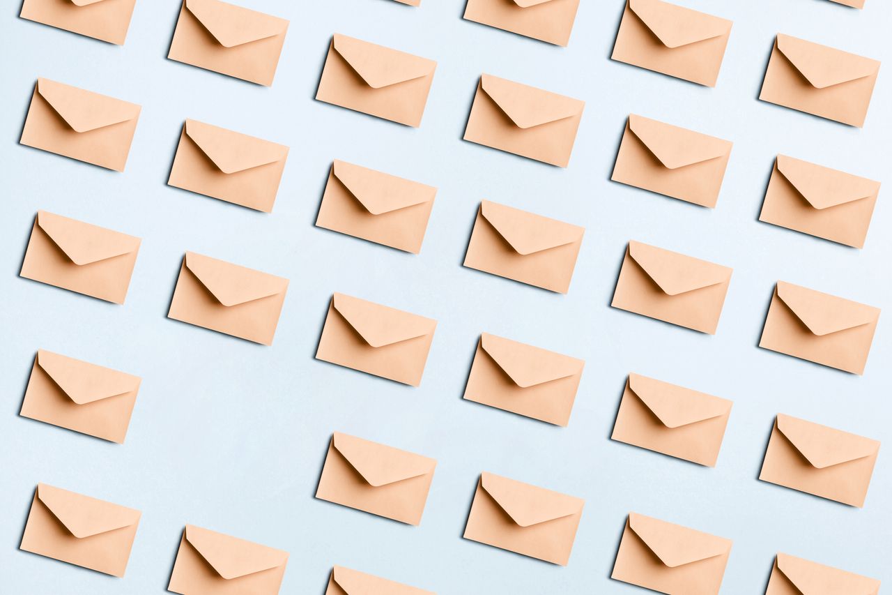 Directly above view of many beige envelopes on a blue colored background for mail