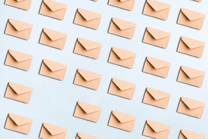 Directly above view of many beige envelopes on a blue colored background for mail