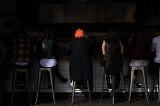 Image taken with Fujifilm X100V, women sitting up at diner counter in shadow