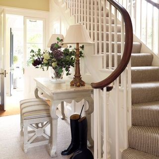 hallway with staircase white table with seat and flower vase