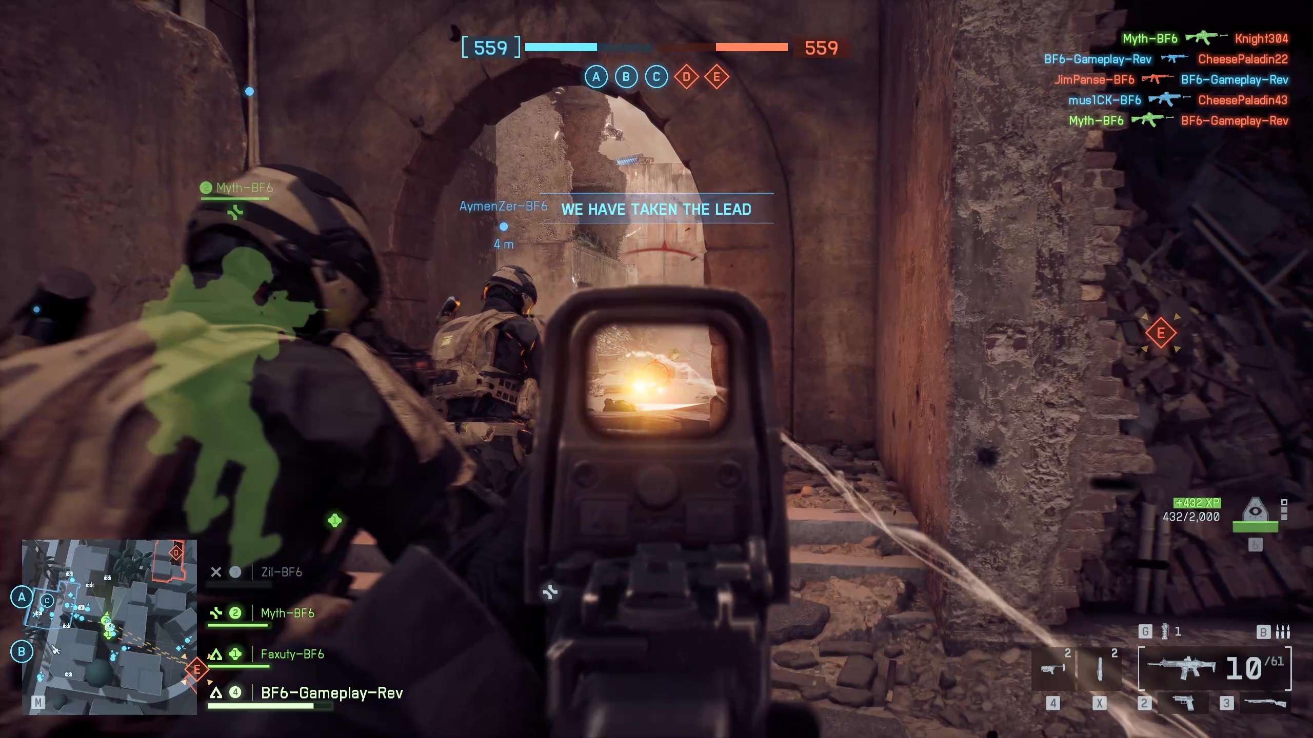 Battlefield 6 multiplayer gameplay showing the player looking down the sight of their gun while three allies clear a narrow street by their side