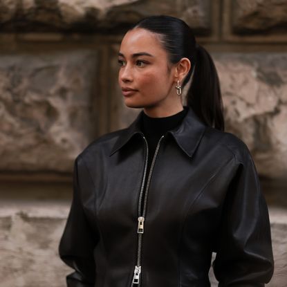 best foundations for oily skin - Kelsey Merritt wearing black leather jacket and silver earrings with sleek ponytail