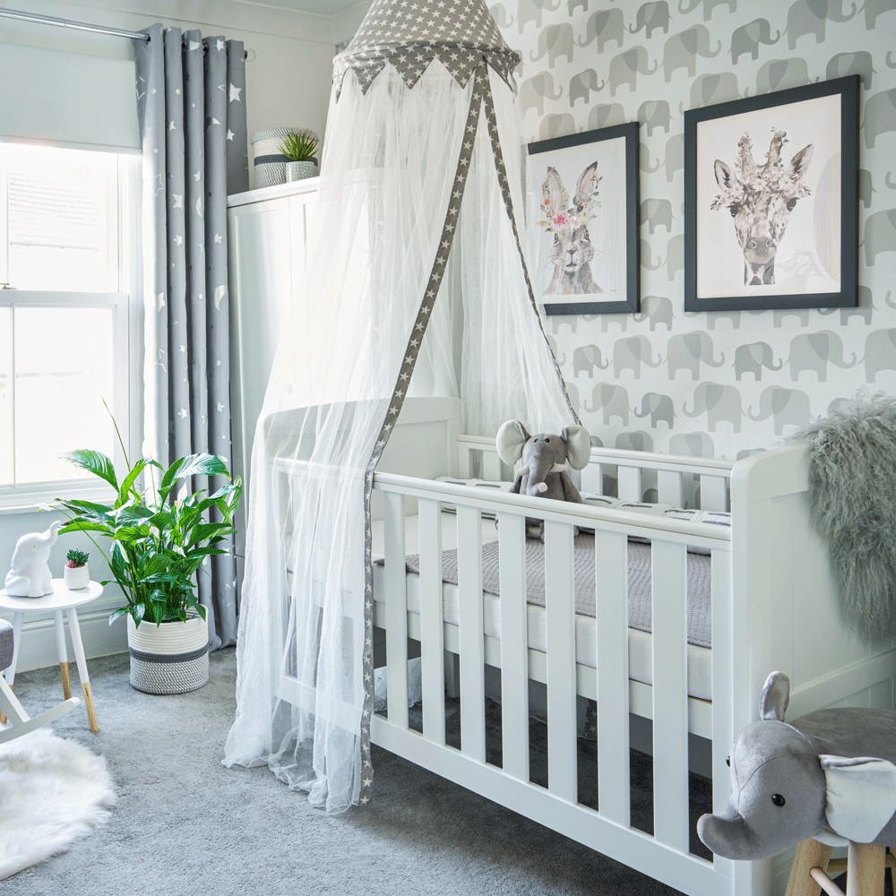 room with white toddler bed with rails and canopy and wallpaper wall and window with curtain