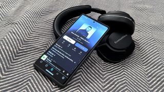 Tidal tips how-to feature showing streming service on smartphone with a pair of B&W headphones