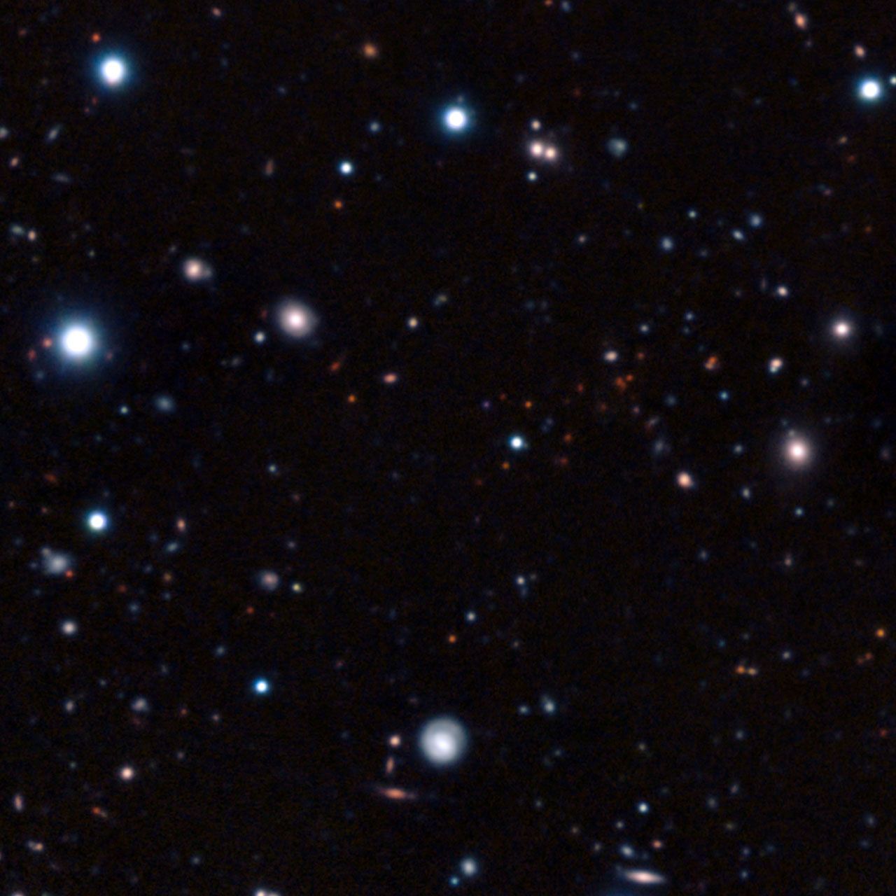 This image The clump of faint red objects to the right of center in this picture is the most remote mature cluster of galaxies yet found. This image is a composite of very long exposures taken with several different telescopes. Most of the visible objects