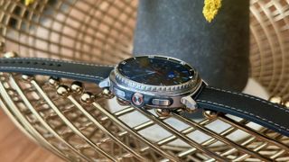 The Samsung Galaxy Watch 8 Classic sitting on top of an ornamental gold bowl, the right side with three buttons showing.