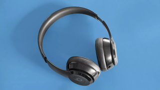 The Beats Solo 3 Wireless headphones pictured on a blue surface.