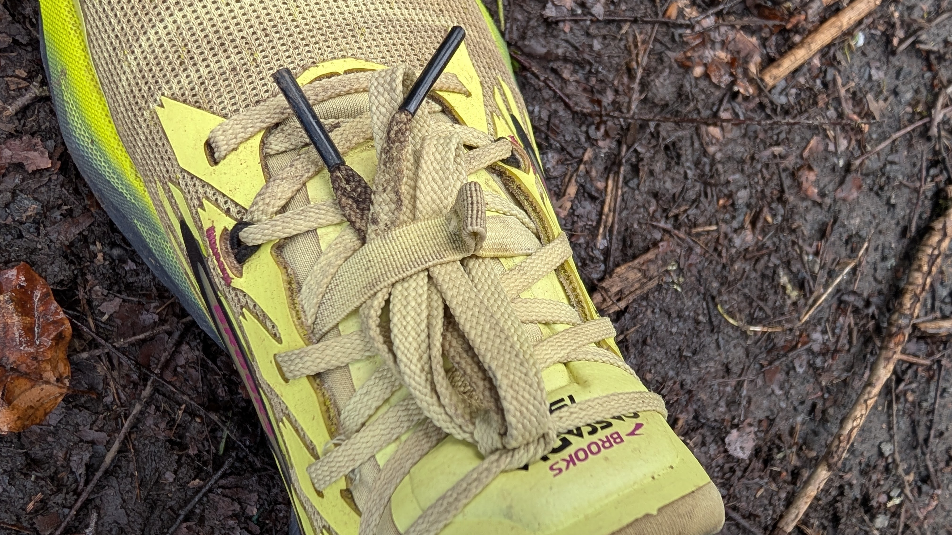 A close-up of the Brooks Cascadia 19 shoes in yellow shoes the laces tucked away