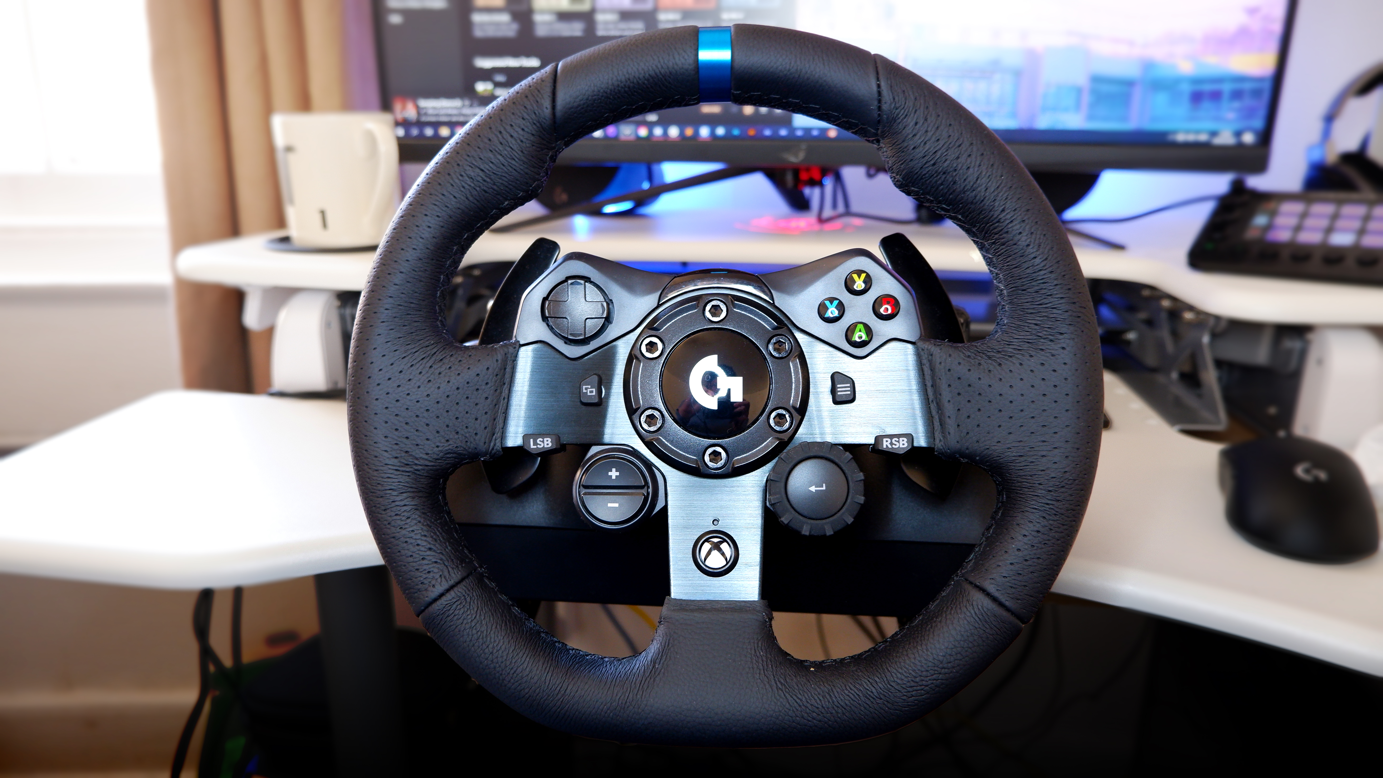 Logitech G923 racing wheel and pedals from various angles at a desk