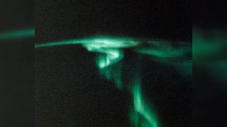 A photo of a green aurora with a spiral-like shape