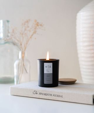 black candle resting on book