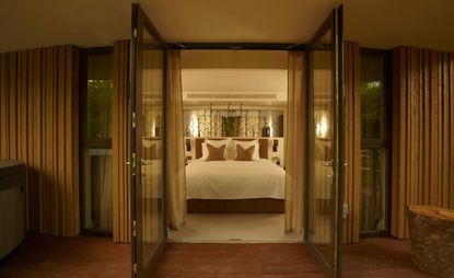 Bedroom at the Treehouse Suites, Chewton Glen Hotel & Spa, Hampshire, UK with white bedding and wooden balcony
