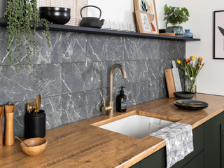 Kitchen with black marble tiles and wooden worktop